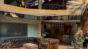 A spacious indoor area with leather sofas, a wooden table, and a decorative plant. - Downtown Treasure Place (Mexico City)