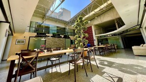 A spacious indoor area with high ceilings, modern furniture, and a large plant centerpiece. - Downtown Treasure Place (Mexico City)
