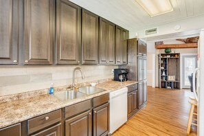 Enjoy cooking in this well-equipped kitchen with a dishwasher and coffee maker, opening into a living area with a city view.