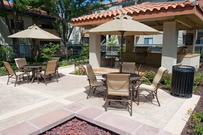 Relax outdoors with a barbecue and dining area, complete with a fire pit and comfortable seating.