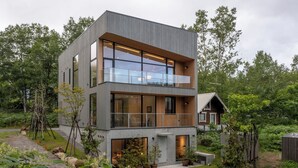 A modern two-story house with large windows, a balcony, and a garden. - Ryoun by H2 Life (Kutchan)