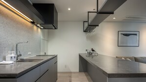 A modern kitchen with two sinks, a built-in oven, and a large island with a marble countertop. - Ryoun by H2 Life (Kutchan)