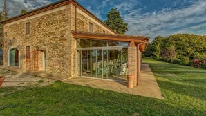 Un bâtiment en pierre doté d’une porte en verre et d’un patio couvert.