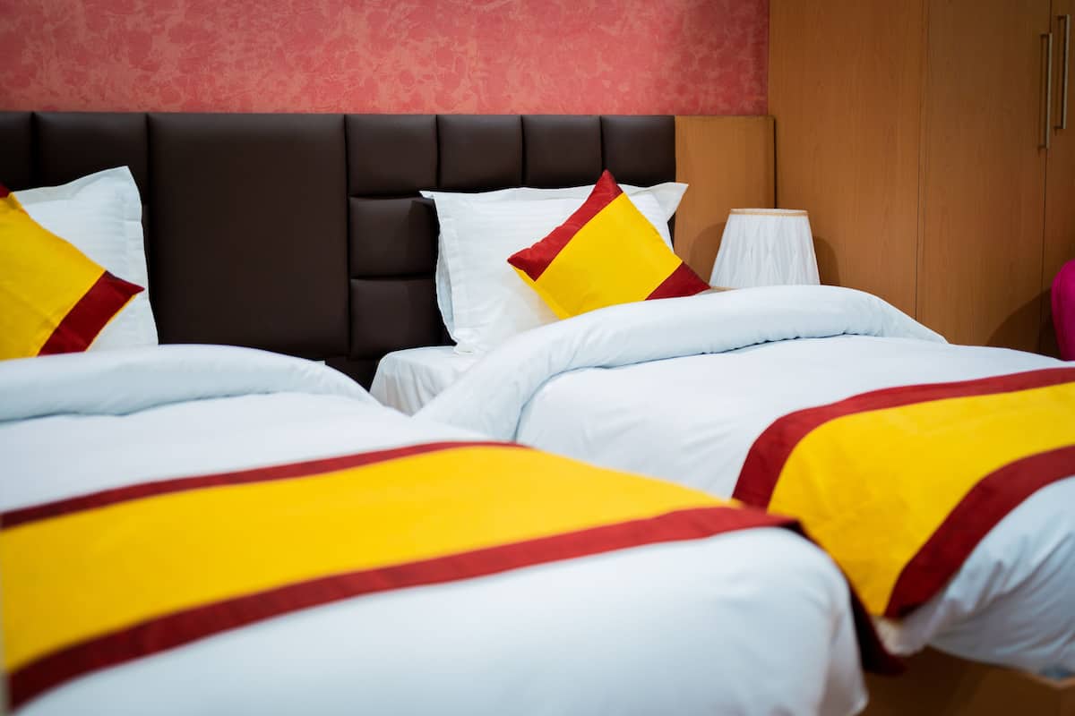 Ein Hotelzimmer mit einem großen Bett, einem Kopfteil und einem Kleiderschrank.