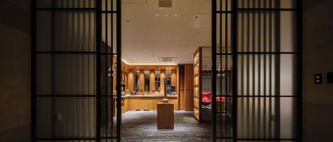 A traditional Japanese interior with sliding doors, a central wooden table, and a red chair.