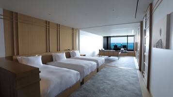 Una habitación de hotel moderna con una cama grande, un escritorio y vistas al océano.