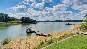 A lake with a dock, a small boat, and a wooden pier. - Boat Dock + Covered Patio: Cherokee Lake Escape! (Mooresburg)