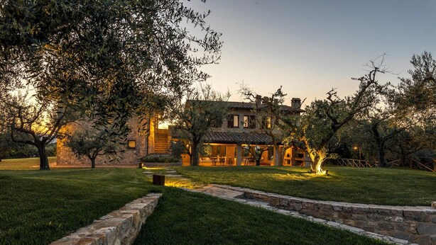 A stone house with a large lawn and trees. - Le Residenze dei Potti 12 (Todi)