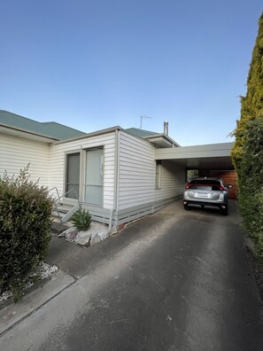 A modern single-story house with a garage, a car parked inside, and a well-maintained driveway. - Central Murtoa Home with Lake view, family friendly. (Murtoa)