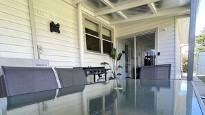A covered outdoor area with a glass table, a grill, and a seating area. - Central Murtoa Home with Lake view, family friendly. (Murtoa)