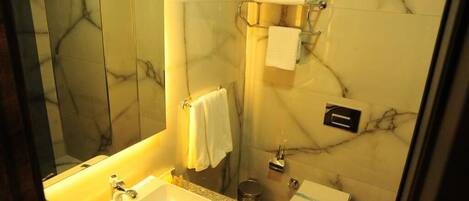 Un bagno con un lavandino in marmo, un water e uno specchio.