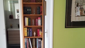 Ein Flur mit einer Holzbücherwand, einem gerahmten Bild an der Wand und einem Holzboden.