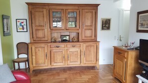 Ein geräumiges Wohnzimmer mit Holzschränken, einem Fernseher und einem roten Sofa.