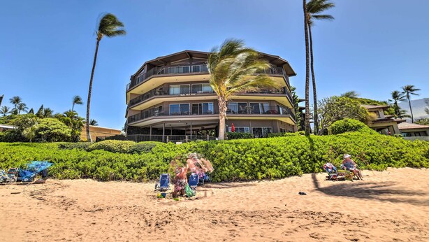 A multi-story hotel with balconies, surrounded by palm trees and a sandy beach. - Gorgeous Oceanfront Kihei Condo w/ Balcony! (Kihei)