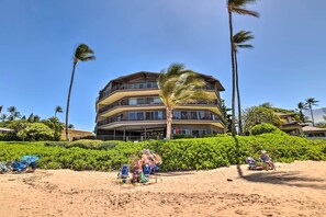 A multi-story hotel with balconies, surrounded by palm trees and a sandy beach. - Gorgeous Oceanfront Kihei Condo w/ Balcony! (Kihei)