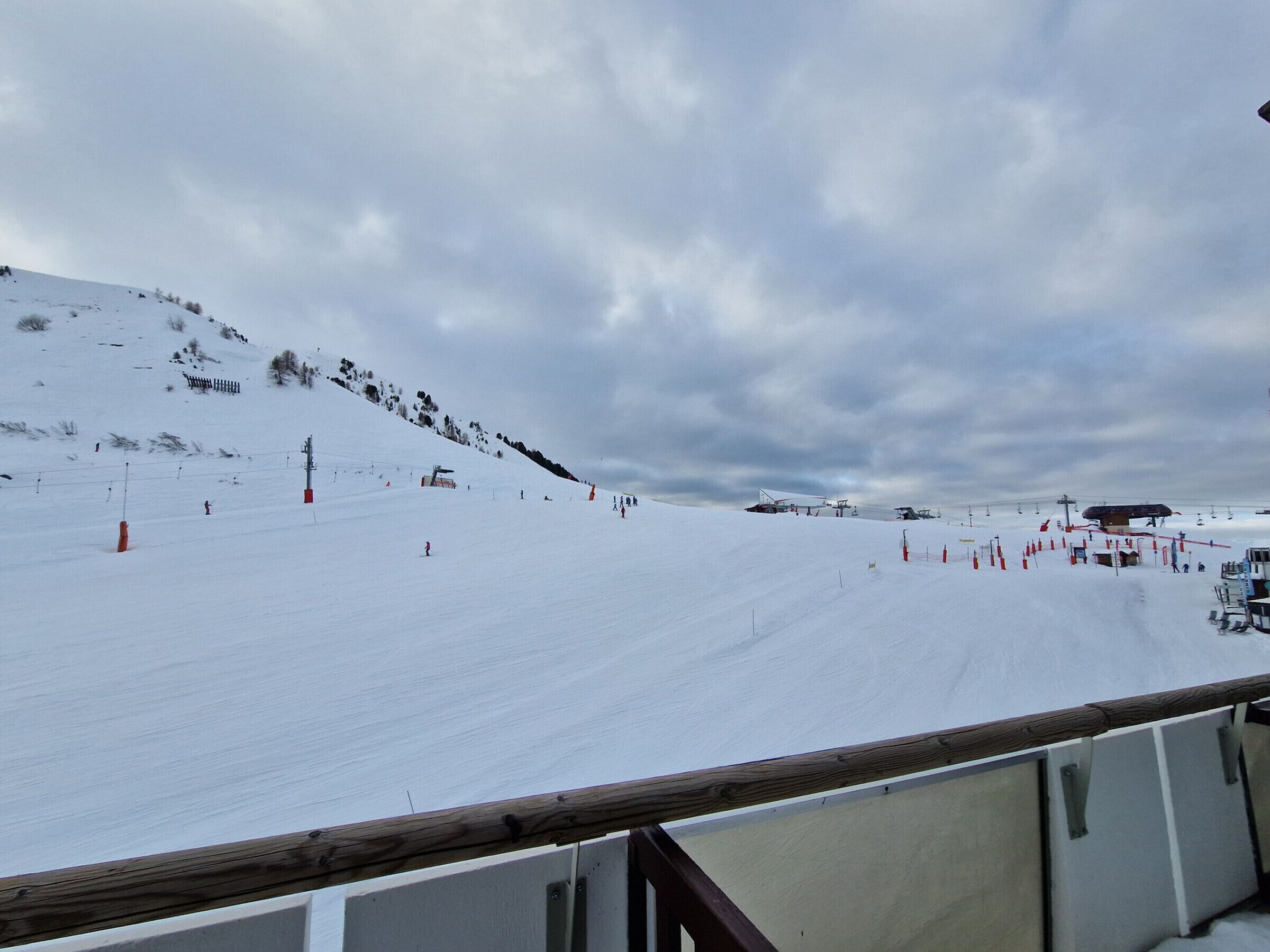 Pista de esquí cubierta de nieve con remontes y barreras de seguridad.