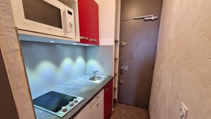 A compact kitchen with a microwave, sink, and stove.