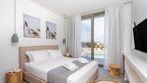 Ein modernes Hotelzimmer mit einem großen Bett, einem Fernseher, Blick ins Freie und einem kleinen Nachttisch.