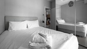 A modern hotel room with a large bed, a bedside table, and a mirror. - Awesome Sea View Nilie Hospitality MGMT (Thessaloniki)
