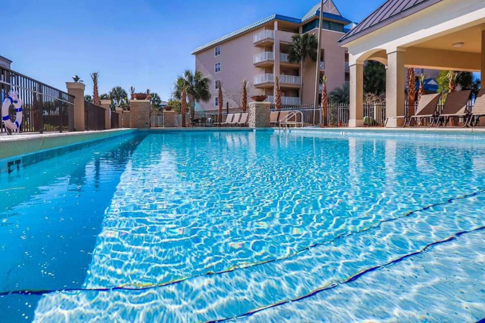 Ein klares Schwimmbecken mit Blick auf Hotelgebäude im Hintergrund.