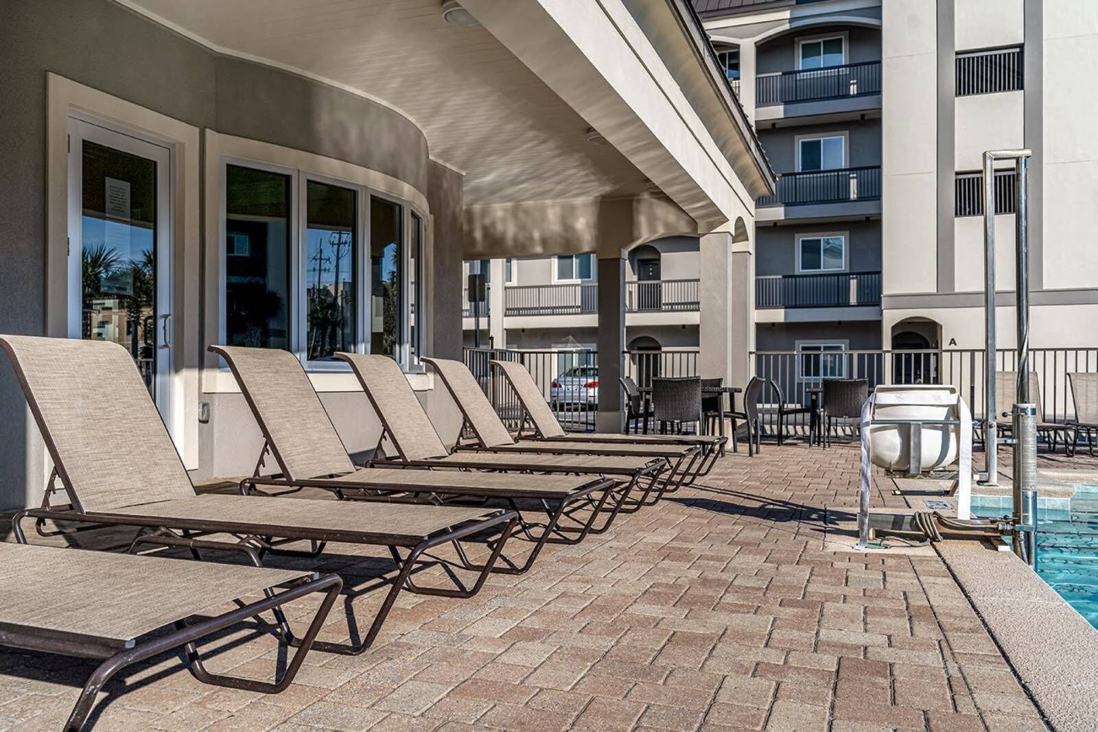 Un espace aménagé au bord de la piscine, avec des chaises longues et une fontaine.