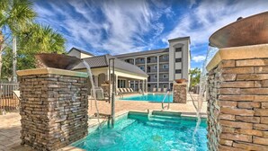 A swimming pool with stone pillars, a covered seating area, and a multi-story building in the background. - Private Balcony! Free Activities! Walk to Beach! Gated Community Alerio B205 (Destin)