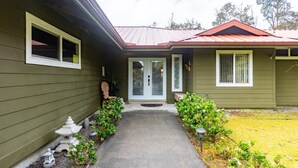 A house with a front porch, a small garden, and a pathway leading to the door. - Lovely, Spacious Villa with HotTub, Outdoor Dining, Fire Pit (Volcano)