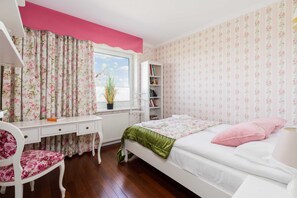 A bedroom with a bed, a desk, a chair, a bookshelf, and a window with curtains. - Comfortable Apartment | Pool Access and Balcony (Poznań)