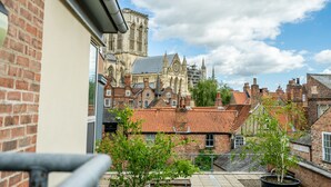 Une vue d’un bâtiment historique, avec une grande cathédrale en arrière-plan, le tout entouré de bâtiments traditionnels en briques.