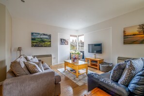 Relax in this stylish living room with two sofas, a flat-screen TV, and a beautiful view.