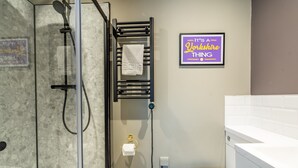 A bathroom with a glass shower enclosure, a towel rack, a toilet, and a framed sign on the wall. - Studio - Sleeps 2 Guests (York)