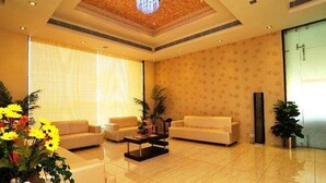 A spacious living room with a large window, a chandelier, and a sofa set. - KRSNA Lila By The Blues Hotels (Sanand)