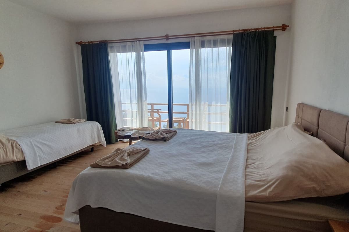 Une chambre d’hôtel avec deux lits, une petite table et une chaise près de la fenêtre.