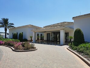 A building with a tiled roof, a covered entrance, and a paved courtyard.