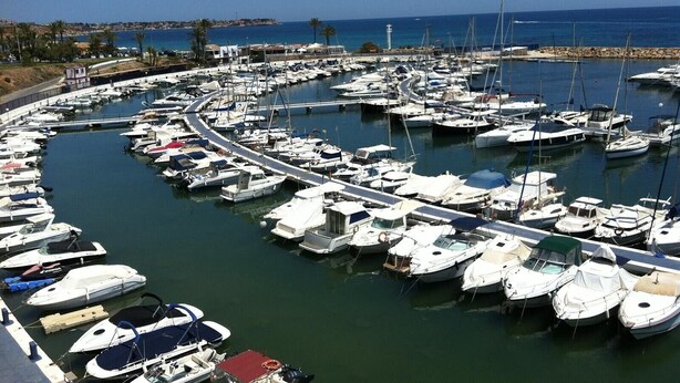 A marina with numerous boats docked in a circular layout, surrounded by a coastal landscape. - Holiday Home 'Beautiful House in Campoamor Golf' with Shared Pool & Wi-Fi (Campoamor)