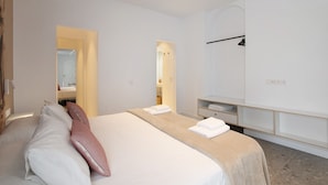 Ein Hotelzimmer mit Bett, Nachttisch, Spiegel und Kleiderschrank.