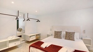 A modern hotel room with a large bed, bedside tables, a mirror, and a red accent wall. - Vacation Home 'Linaje del Pago Negramol' with Sea View, Pool & Wi-Fi (Sauzal)