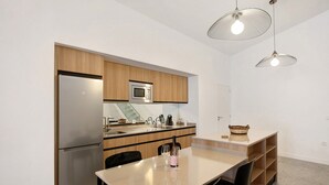 A modern kitchen with a refrigerator, microwave, and dining area. - Vacation Home 'Linaje del Pago Negramol' with Sea View, Pool & Wi-Fi (Sauzal)