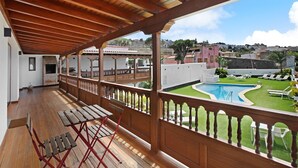 A covered balcony with wooden beams, a pool, and a view of a residential area. - Vacation Home 'Linaje del Pago Malvasia' with Sea View, Pool, Private Balcony & Wi-Fi (Sauzal)