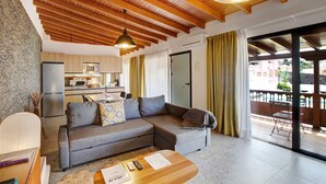 A modern living room with a sofa, a coffee table, and a kitchen in the background. - Vacation Home 'Linaje del Pago Malvasia' with Sea View, Pool, Private Balcony & Wi-Fi (Sauzal)