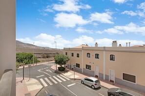 A street view with a building, a car, and a clear sky.