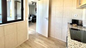 Eine moderne Küche mit Holzboden, einer Granitarbeitsplatte und einem eingebauten Geschirrspüler.