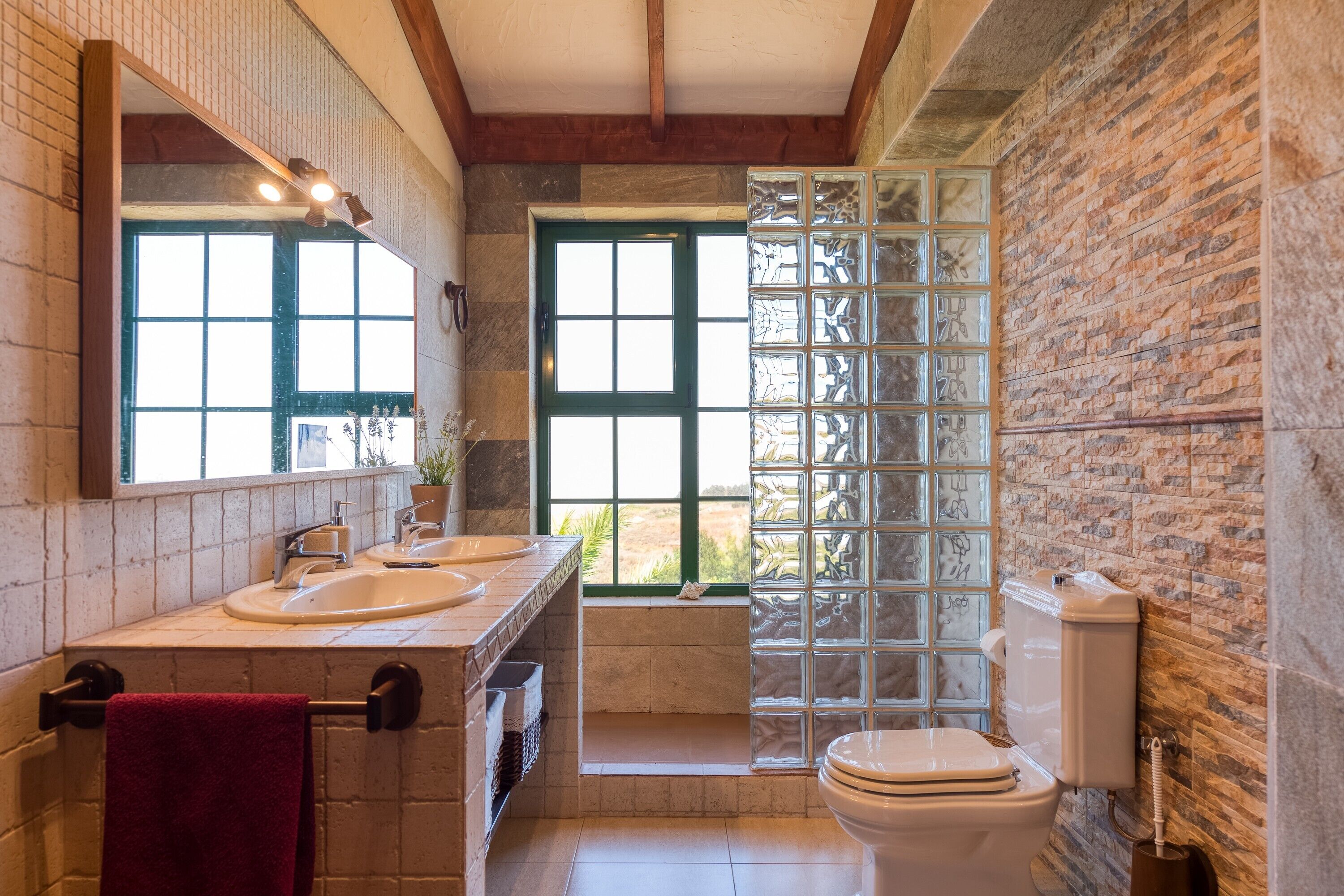 Een badkamer met een groot raam, een badkuip en een toilet.