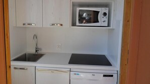 A compact kitchen with a built-in microwave, a sink, and a dishwasher. - 100m from ski slopes, 3rd floor, view ski slopes/ski slopes, balcony, tv, 28m², La Plagne (La Plagne)