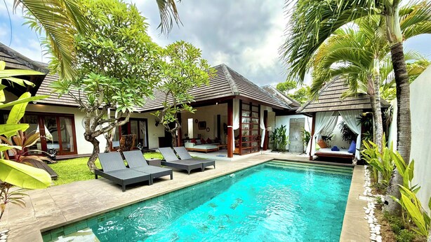 A swimming pool with lounge chairs, a covered seating area, and tropical plants. - NIL VILLA SEMINYAK - 3 BEDROOMS (Bali)