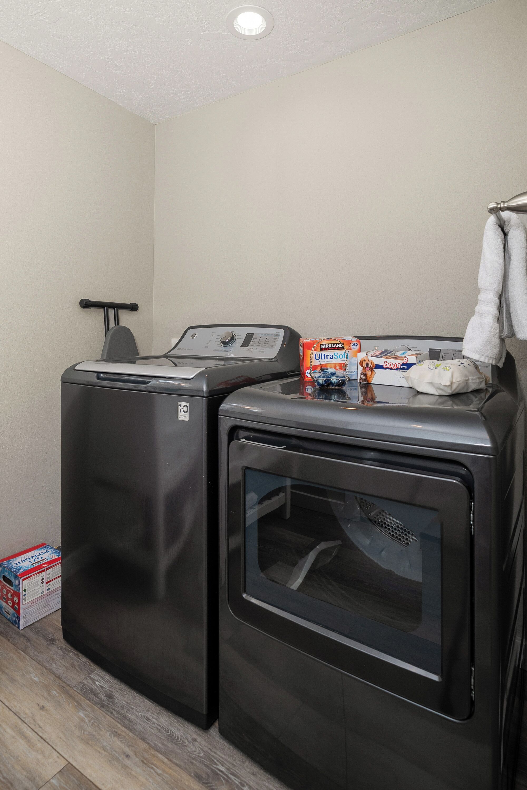 A laundry area with two front-loading washing machines and a dryer.