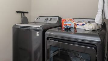 A laundry area with two front-loading washing machines and a dryer.