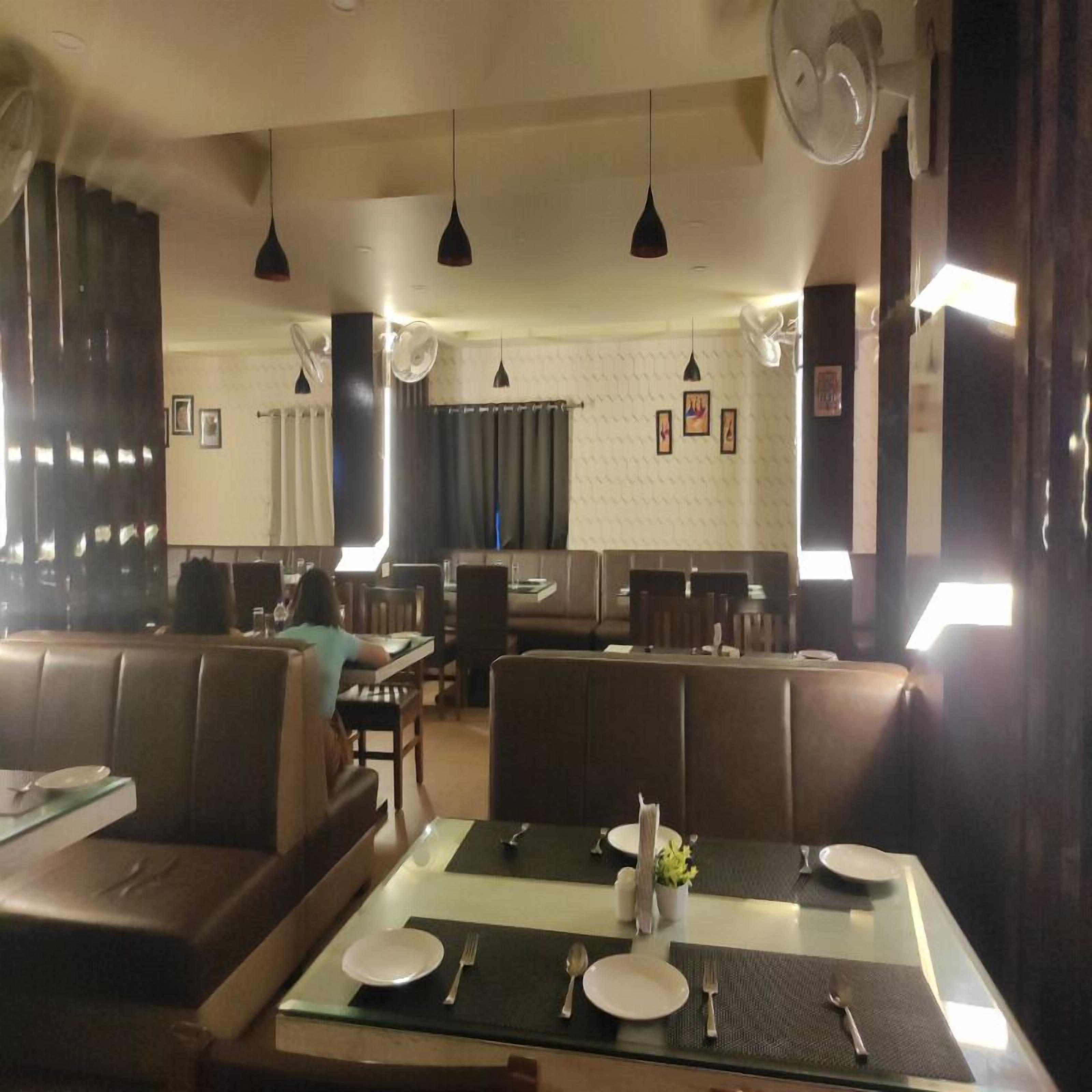 Un restaurante con cabinas y mesas, algunas con manteles y cubiertos.