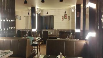 Un restaurante con cabinas y mesas, algunas con manteles y cubiertos.