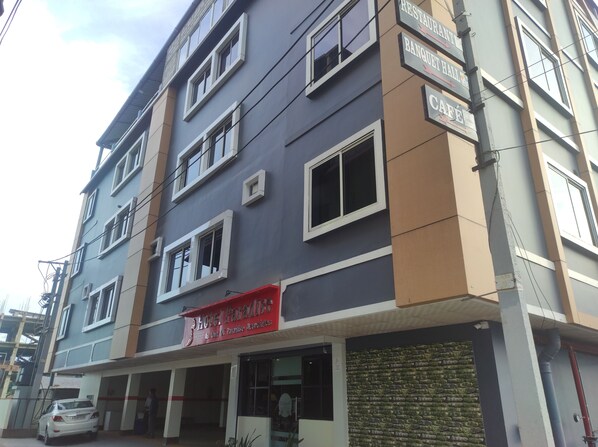 Un edificio de varios pisos con un cartel que dice 'Hotel Paradise' en la planta baja.